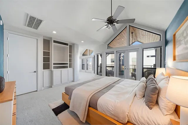 a bedroom with a bed a large window and chandelier