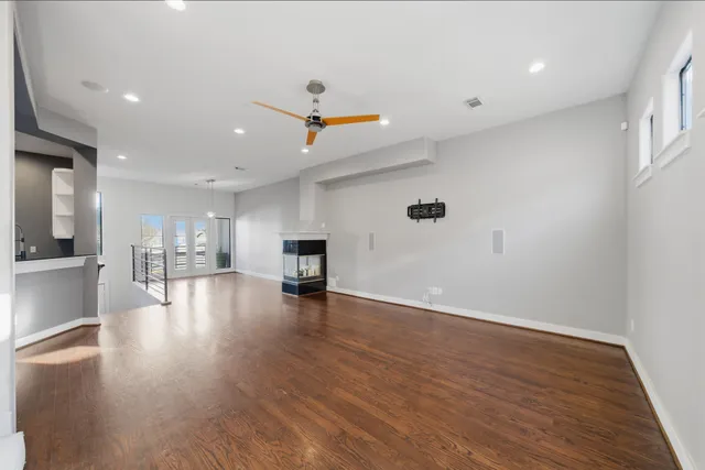 a view of empty room with wooden floor and windows