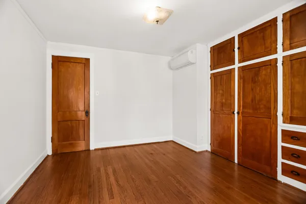 an empty room with wooden floor and closet