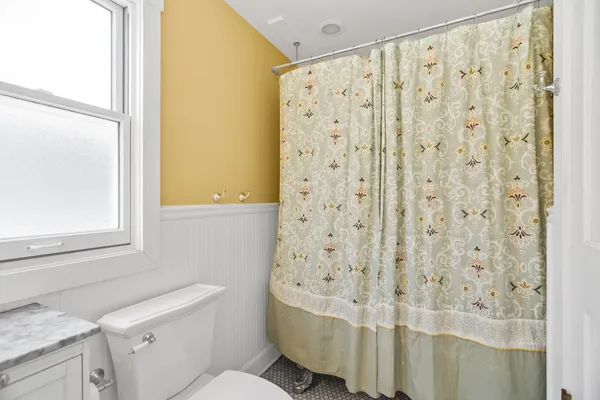 a bathroom with a sink a toilet and shower curtain
