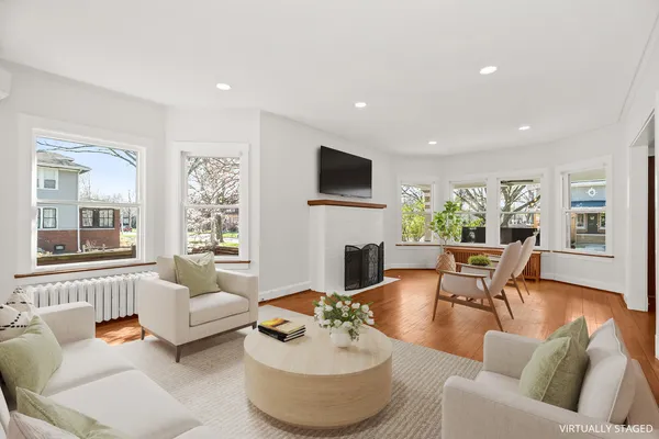 a living room with furniture fireplace and a large window
