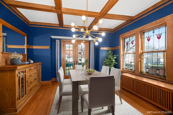 a dining room with furniture a chandelier and wooden floor