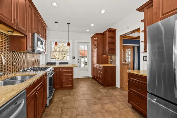 a kitchen with stainless steel appliances granite countertop a refrigerator and a stove top oven