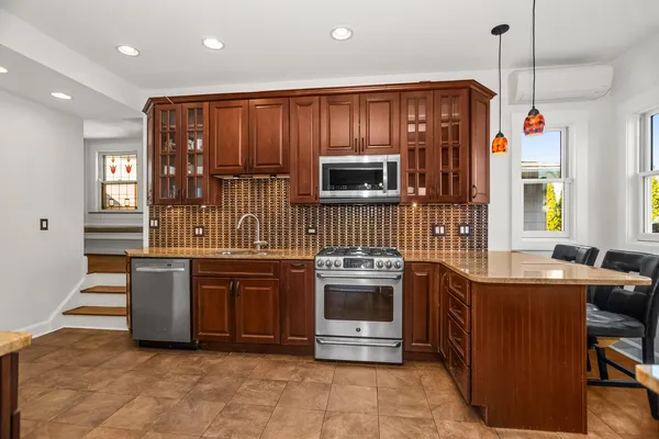 a kitchen with stainless steel appliances granite countertop a stove top oven a sink dishwasher and a refrigerator
