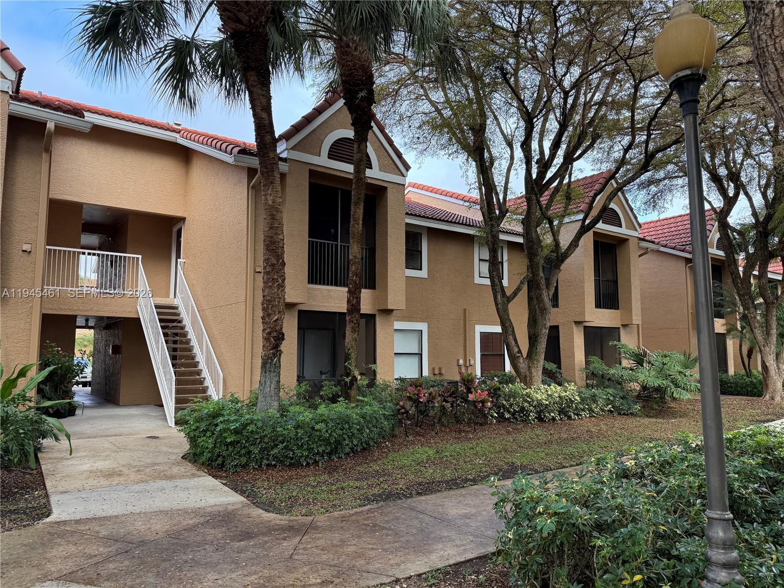 10441 Southwest 156th Court, Unit 429 Miami, FL 33196 - Photo 2 of 17 a front view of a house with a garden