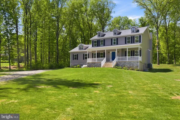a view of a house with a big yard and large trees