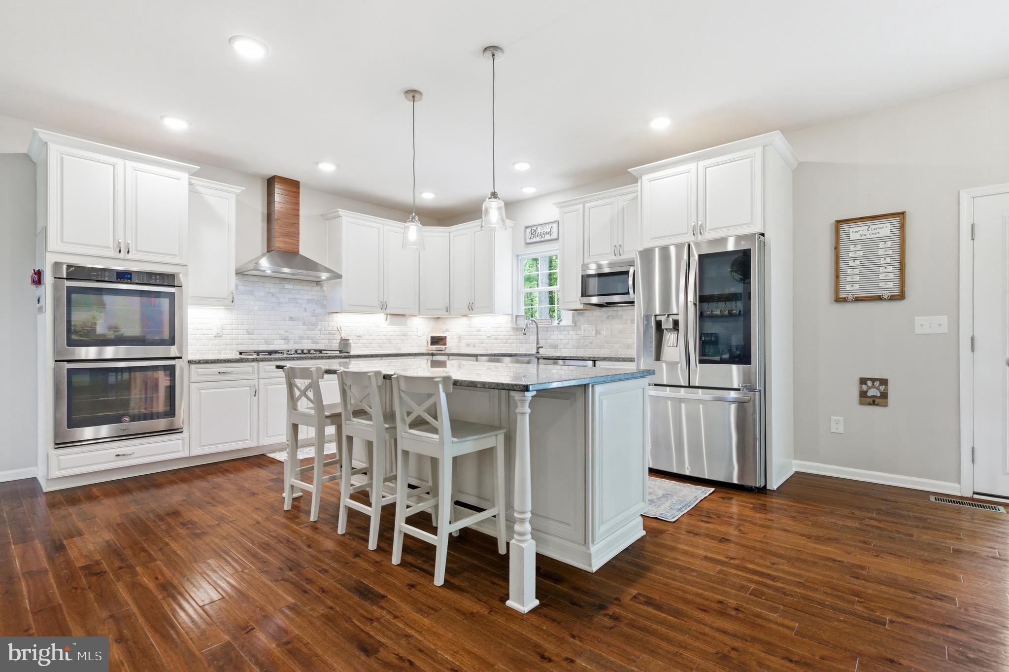 6324 Vint Hill Road Warrenton, VA 20187 - Photo 31 of 103 a kitchen with stainless steel appliances kitchen island granite countertop a refrigerator a stove a oven and white cabinets with wooden floors