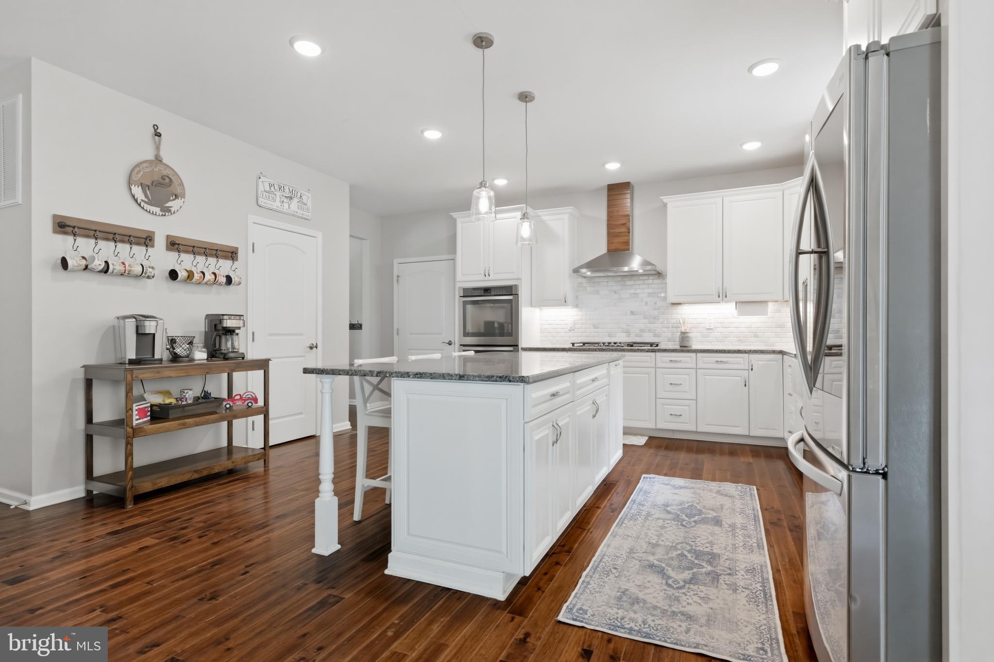 6324 Vint Hill Road Warrenton, VA 20187 - Photo 33 of 103 a kitchen with stainless steel appliances granite countertop a refrigerator a sink dishwasher a stove and white cabinets with wooden floor