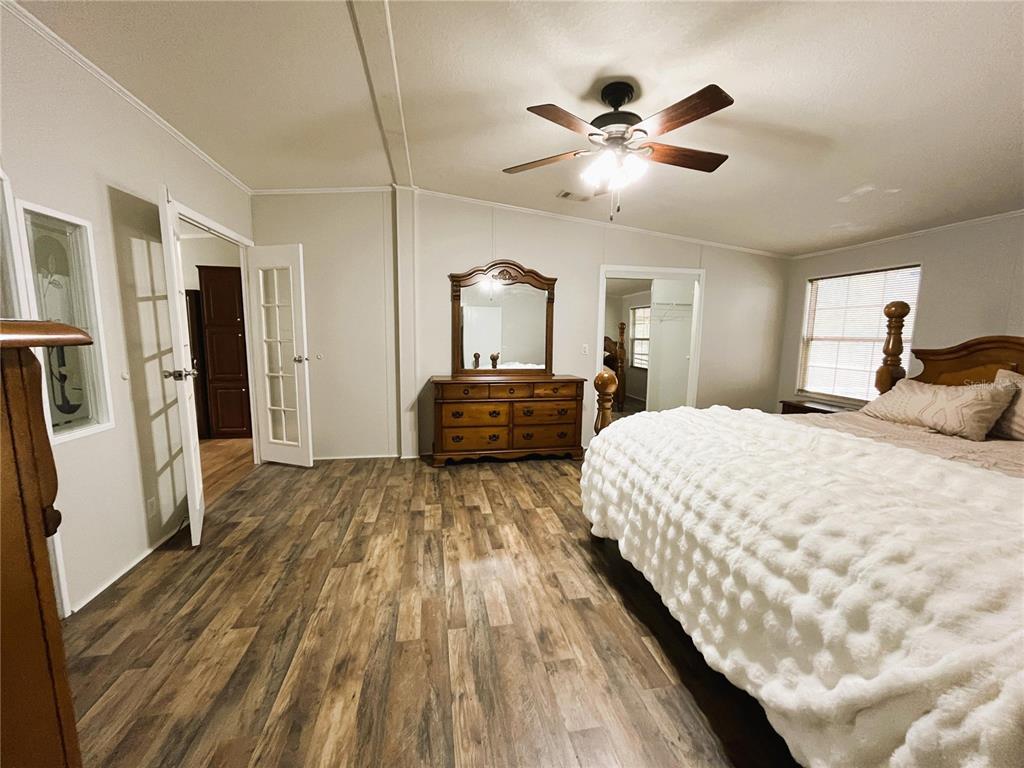 7750 156th Terrace Live Oak, FL 32060 - Photo 16 of 41 a bedroom with a large bed and a chandelier