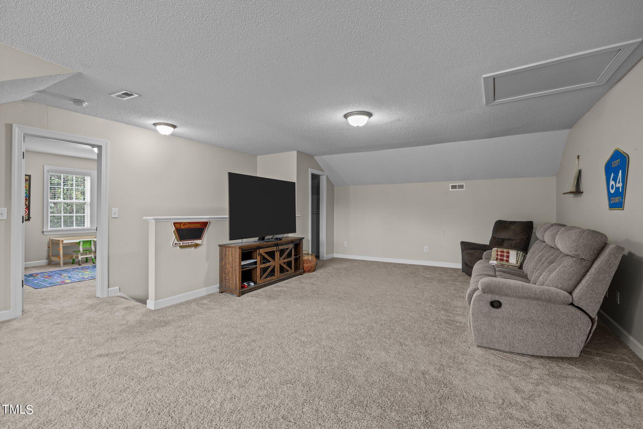 8809 Oregon Inlet Court Raleigh, NC 27603 - Photo 39 of 53 a living room with furniture and a flat screen tv