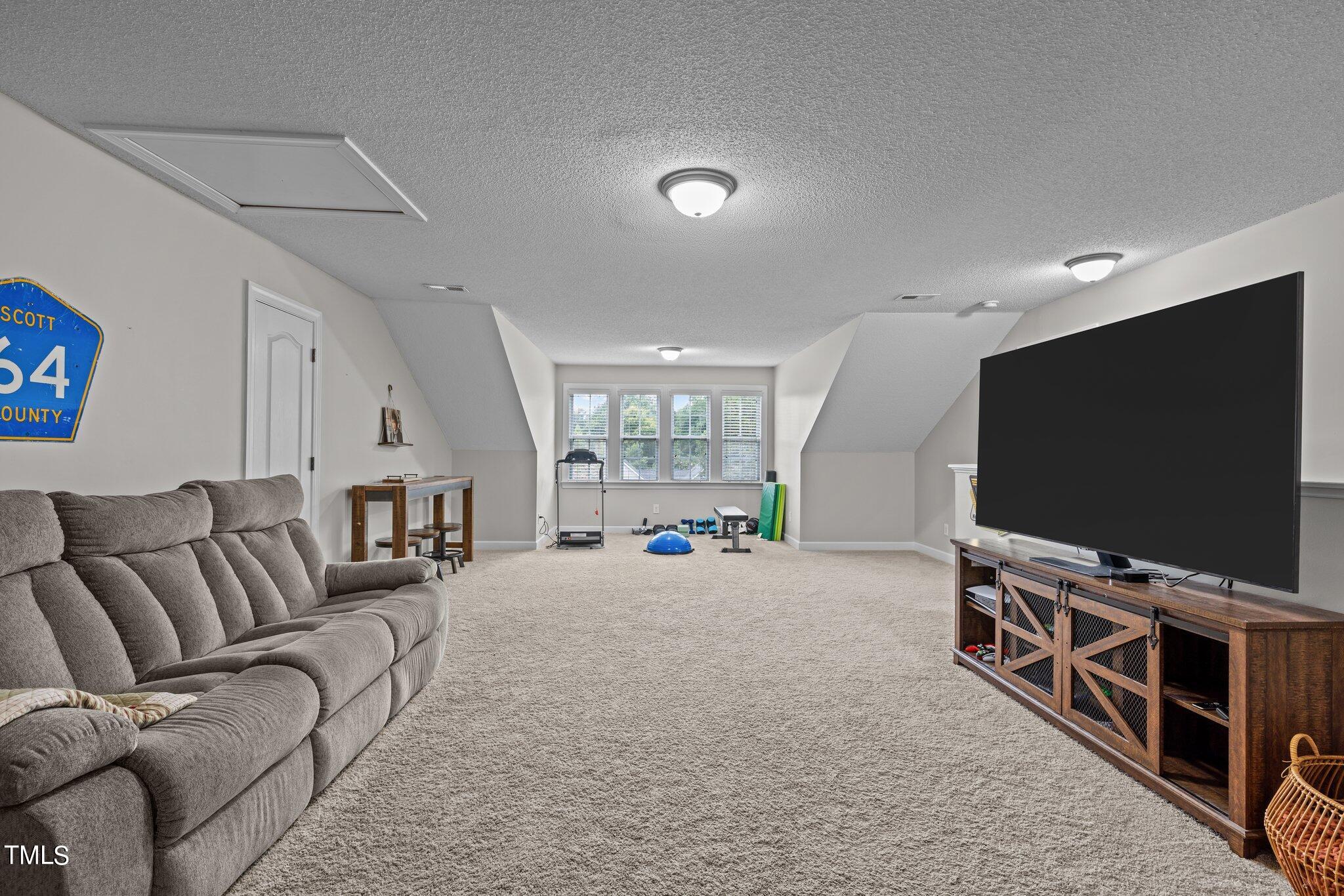 8809 Oregon Inlet Court Raleigh, NC 27603 - Photo 8 of 53 a living room with furniture and a flat screen tv