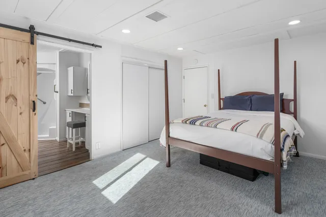 a spacious bedroom with a bed and a refrigerator