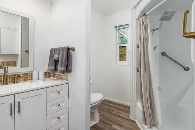 a bathroom with a granite countertop sink toilet and shower