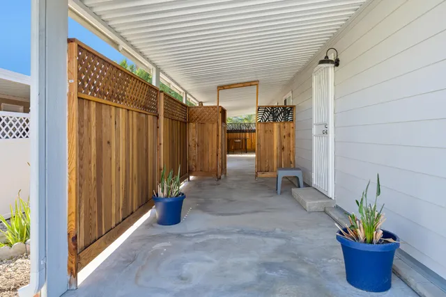 a view of a balcony with chairs and potted plants