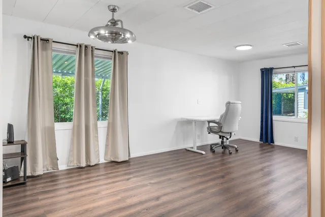 a view of a workspace with furniture and a window