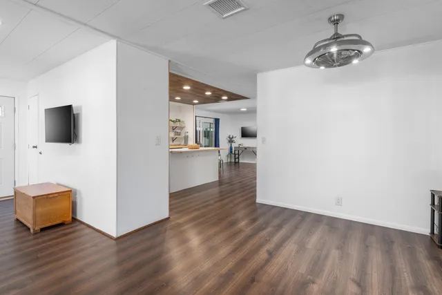 a view of a livingroom with wooden floor and a sink