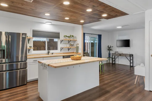 a kitchen with stainless steel appliances granite countertop a sink and a refrigerator