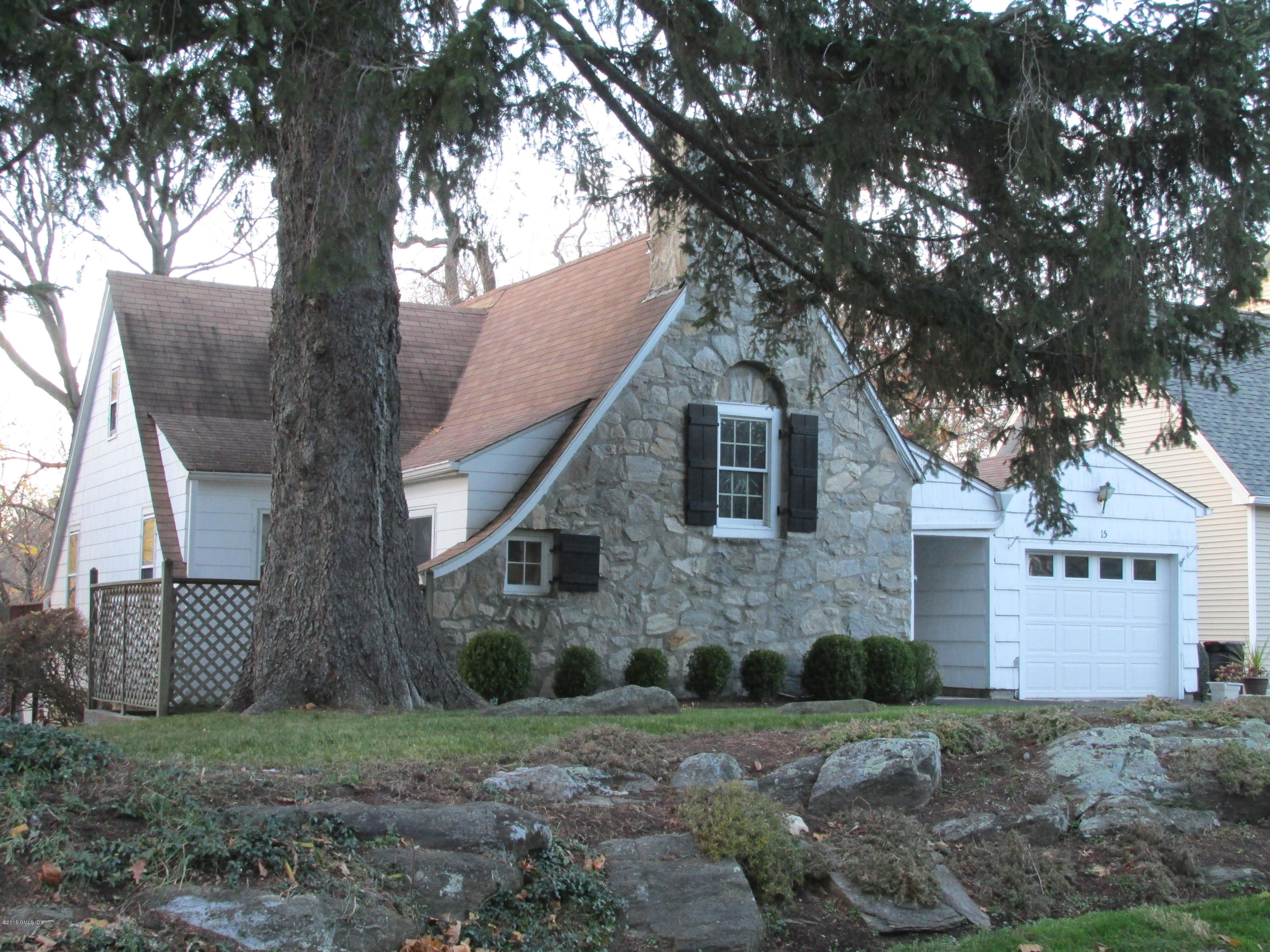 a view of a brick house next to a large tree