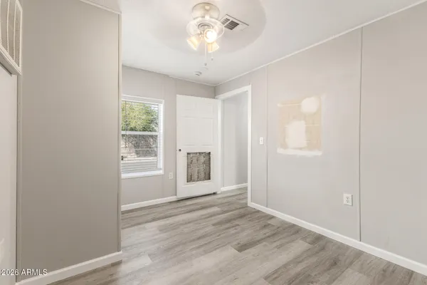 an empty room with wooden floor and windows