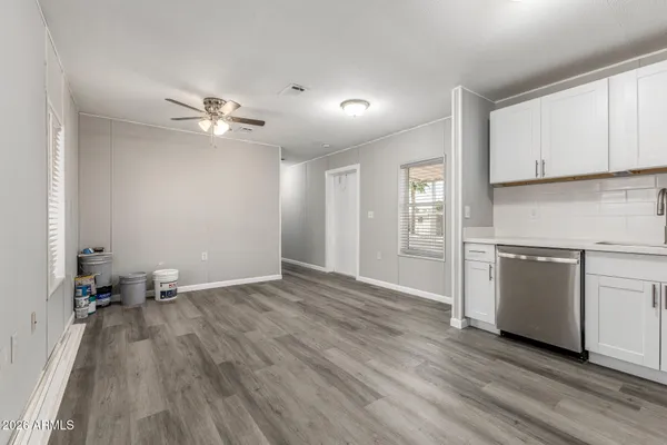 a kitchen with granite countertop wooden floors stainless steel appliances and sink
