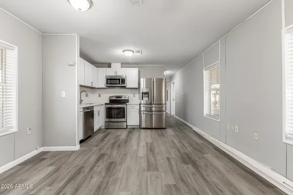a kitchen with wooden floors and stainless steel appliances