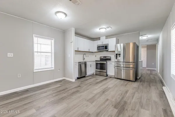 a kitchen with cabinets stainless steel appliances and wooden floor