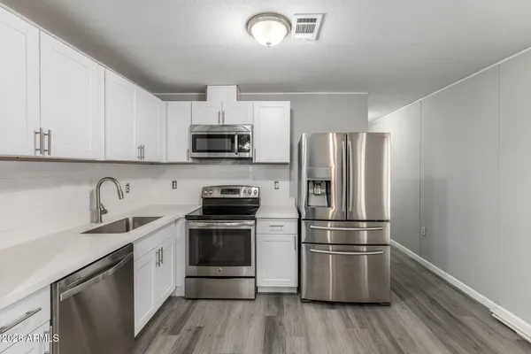 a kitchen with cabinets stainless steel appliances and a window