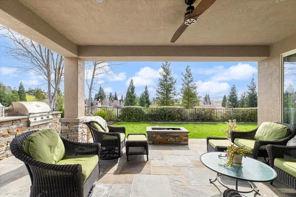 a view of a white house with a yard and table and chairs under an umbrella