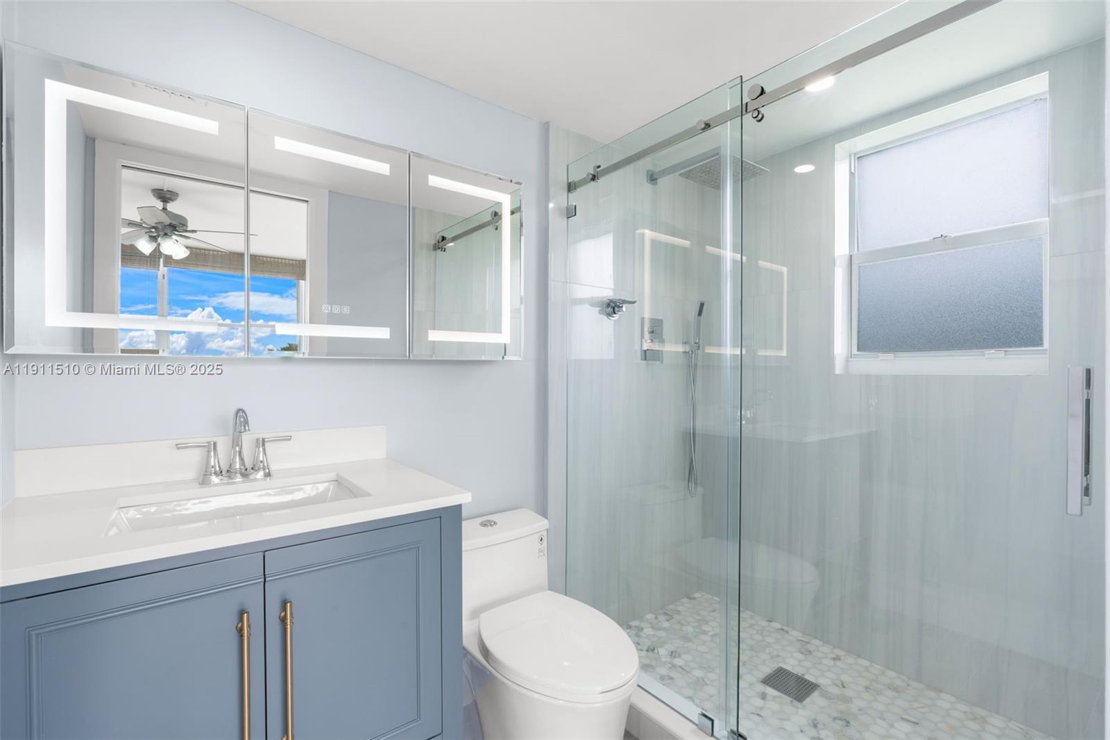 7640 Northwest 18th Street, Unit 301 Margate, FL 33063 - Photo 16 of 35 a bathroom with a sink a mirror a toilet and shower