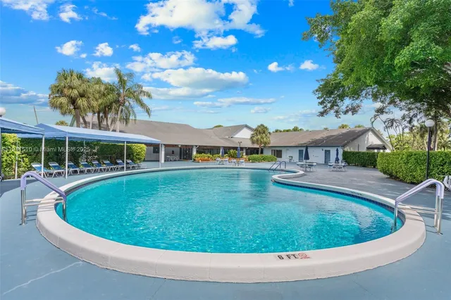 a view of a house with swimming pool and sitting area