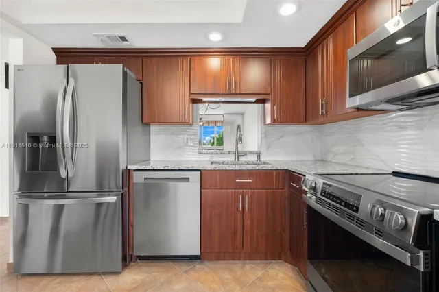a kitchen with granite countertop a refrigerator stove and microwave
