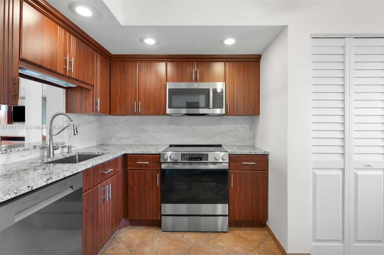 7640 Northwest 18th Street, Unit 301 Margate, FL 33063 - Photo 5 of 35 a kitchen with sink a microwave and cabinets