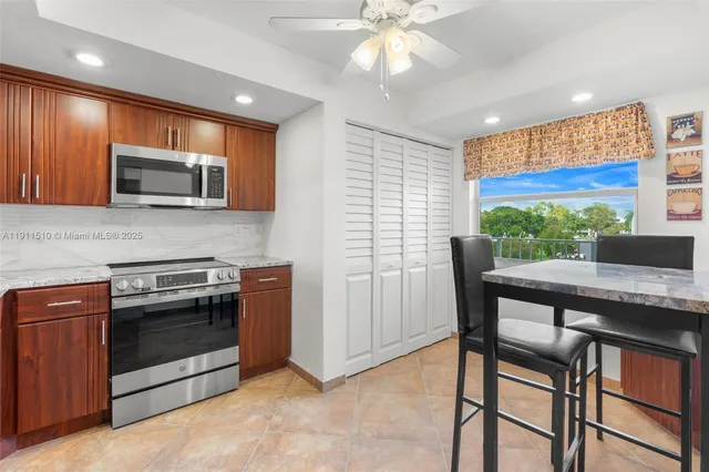 a kitchen with stainless steel appliances granite countertop wooden cabinets a stove top oven a sink and dishwasher