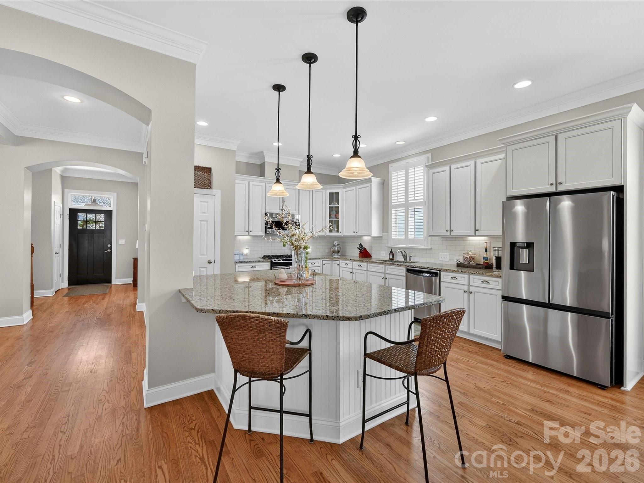4265 Birkshire Heights Fort Mill, SC 29708 - Photo 14 of 47 a kitchen with stainless steel appliances granite countertop a dining table chairs refrigerator and sink