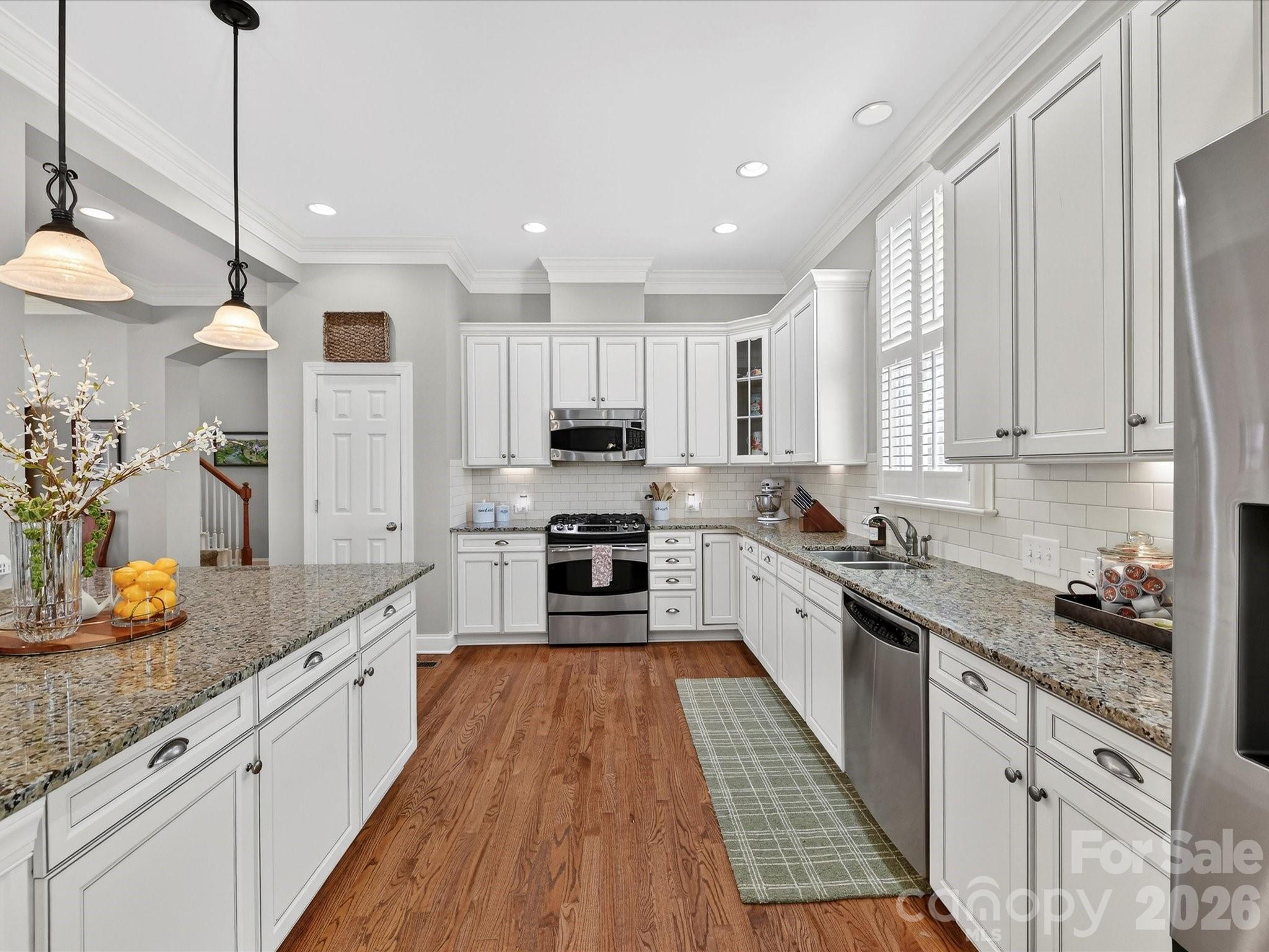 4265 Birkshire Heights Fort Mill, SC 29708 - Photo 15 of 47 a large kitchen with stainless steel appliances lots of counter space and wooden floors