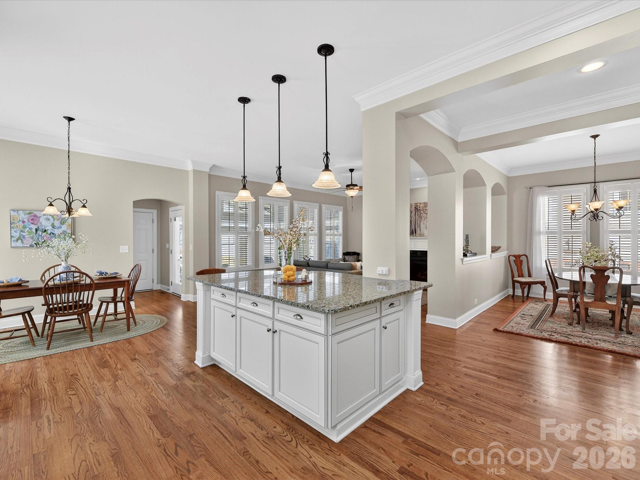 4265 Birkshire Heights Fort Mill, SC 29708 - Photo 16 of 47 a kitchen with stainless steel appliances granite countertop a stove oven a dining table chairs and couches with wooden floor