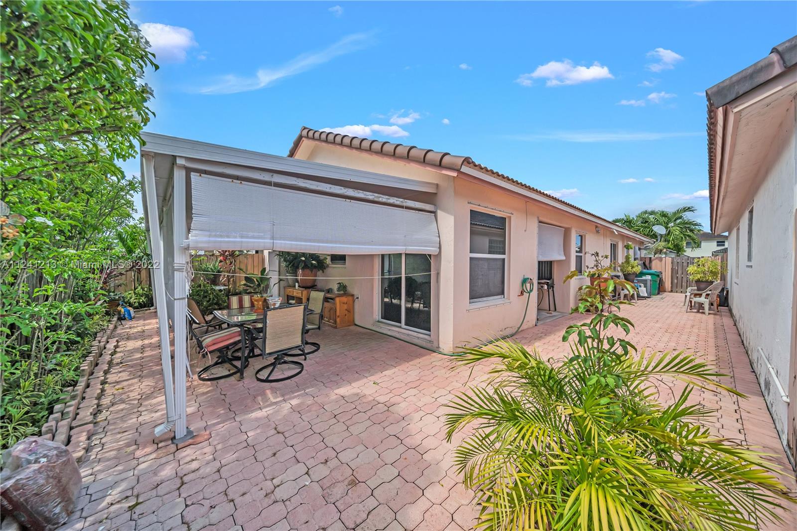 14202 Southwest 151st Court Miami, FL 33196 - Photo 18 of 23 a view of a patio with table and chairs near a yard