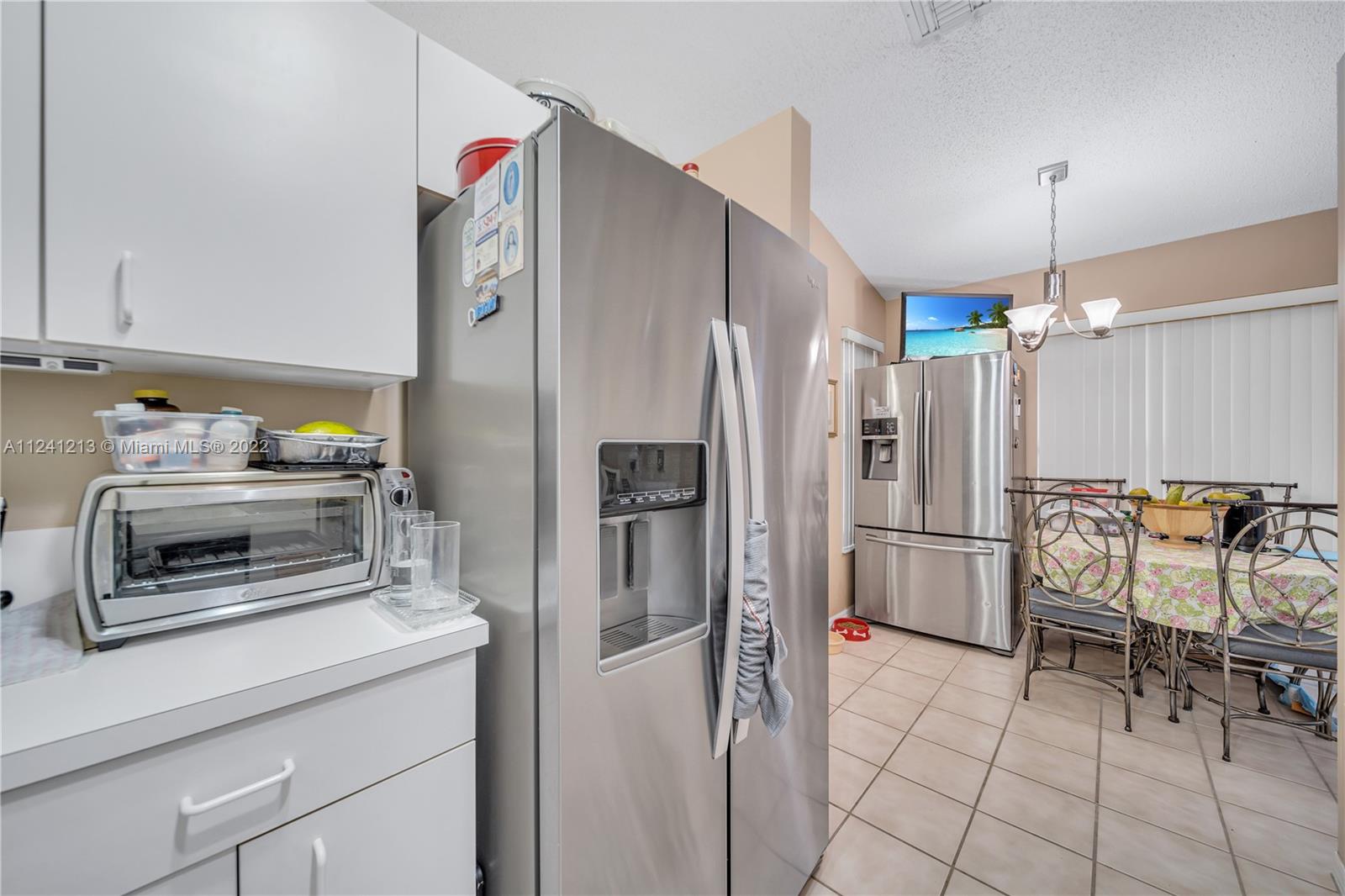 14202 Southwest 151st Court Miami, FL 33196 - Photo 7 of 23 a kitchen with granite countertop a refrigerator and a stove top oven