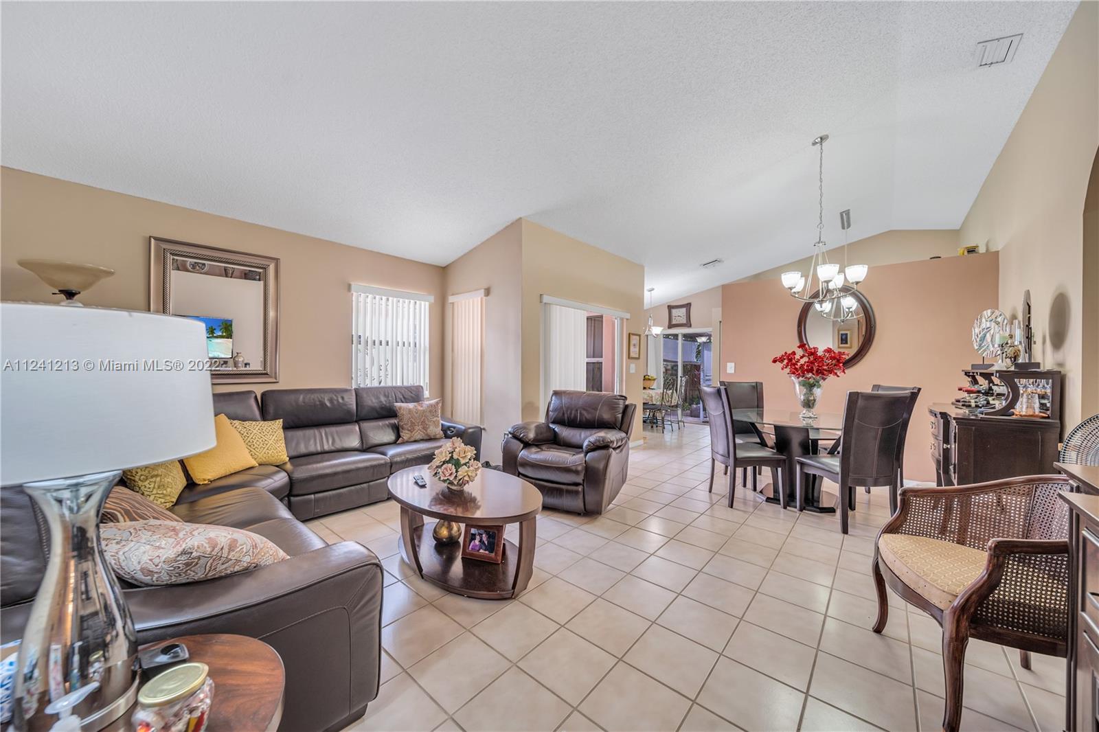 14202 Southwest 151st Court Miami, FL 33196 - Photo 10 of 23 a living room with furniture a rug and a chandelier