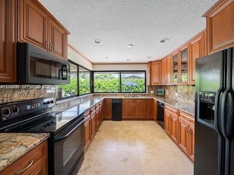 11350 Southwest 30th Street Miami, FL 33165 - Photo 17 of 25 a large kitchen with stainless steel appliances granite countertop a stove and a refrigerator
