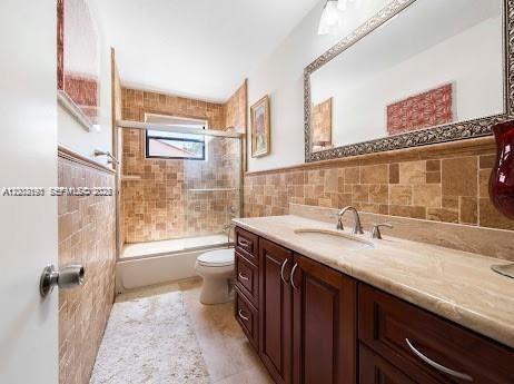 11350 Southwest 30th Street Miami, FL 33165 - Photo 20 of 25 a bathroom with a granite countertop sink a toilet a mirror and shower