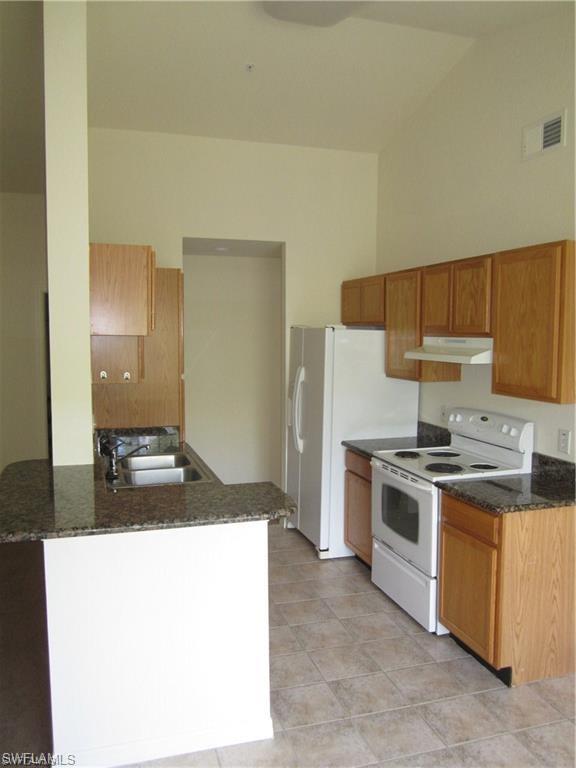 7960 Preserve Circle, Unit 634 Naples, FL 34119 - Photo 3 of 12 a kitchen with a stove and a refrigerator