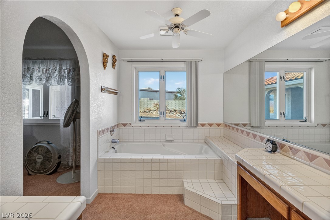 2055 Cholla Way Laughlin, NV 89029 - Photo 39 of 87 A deep soaking tub awaits in this sun-drenched primary bathroom.