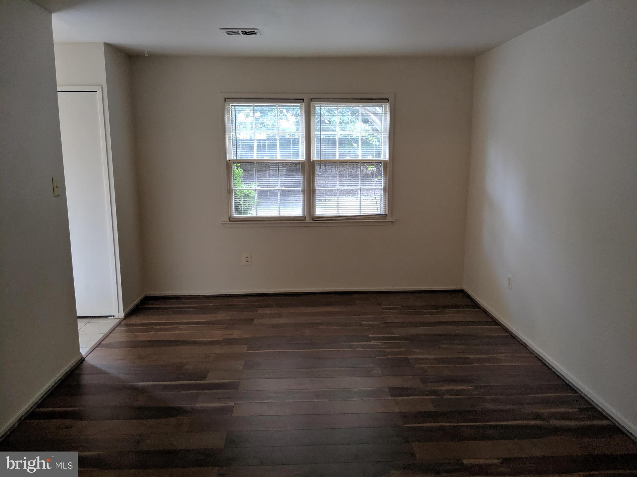 7760 Matisse Way Springfield, VA 22153 - Photo 4 of 21 a view of an empty room with wooden floor and a window