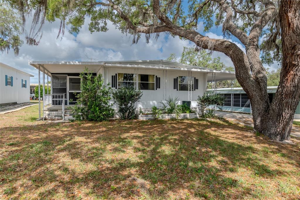 7305 Score Street Brooksville, FL 34613 - Photo 1 of 1 a front view of house with yard and trees in the background