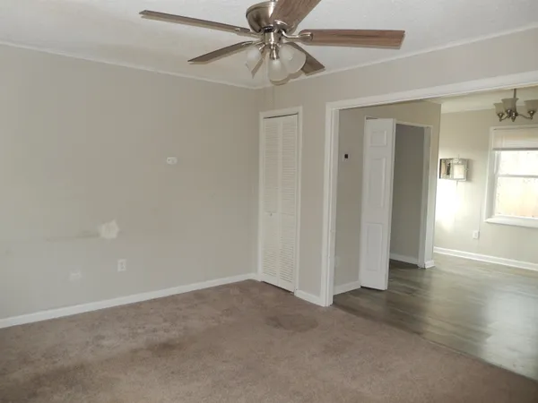 wooden floor in an empty room with a kitchen