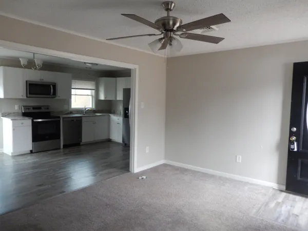 a kitchen with stainless steel appliances granite countertop a stove top oven a sink dishwasher a refrigerator and a microwave oven with wooden floor