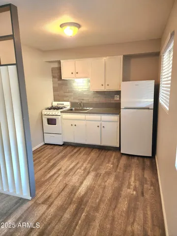 a kitchen with granite countertop white cabinets and white appliances