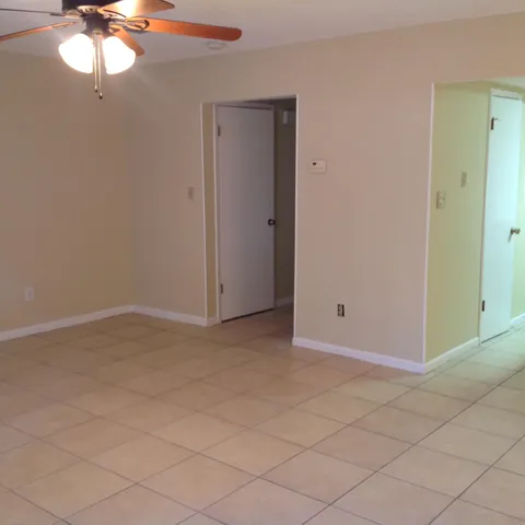 an empty room with a chandelier fan