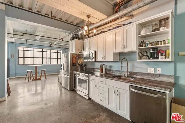 a kitchen with stainless steel appliances granite countertop a sink a stove and cabinets